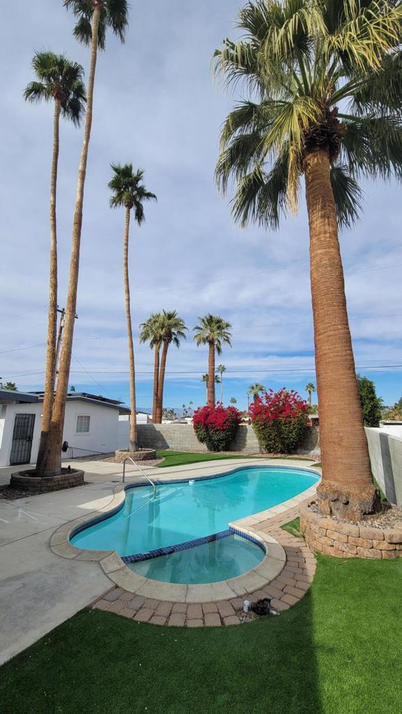 view of swimming pool featuring an in ground hot tub, a patio area, and a lawn