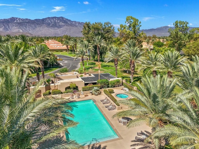 view of swimming pool featuring a mountain view, a hot tub, and a patio