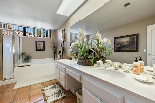 bathroom with tile patterned floors, vanity, a skylight, and independent shower and bath