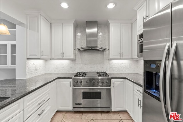 kitchen featuring white cabinetry, stainless steel appliances, light tile patterned floors, and wall chimney range hood