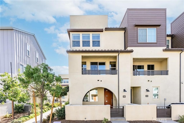 view of front of home with a balcony and central AC unit