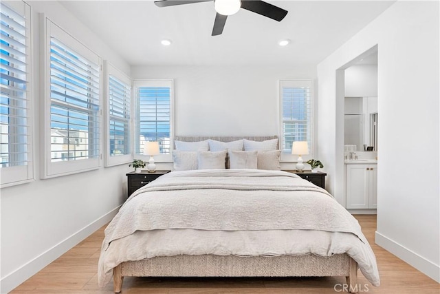 bedroom featuring light wood-type flooring, ceiling fan, and ensuite bath