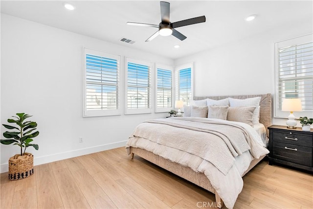 bedroom with light wood-type flooring, ceiling fan, and multiple windows