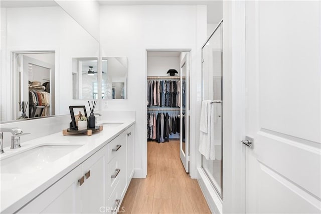 bathroom featuring hardwood / wood-style floors, an enclosed shower, and vanity