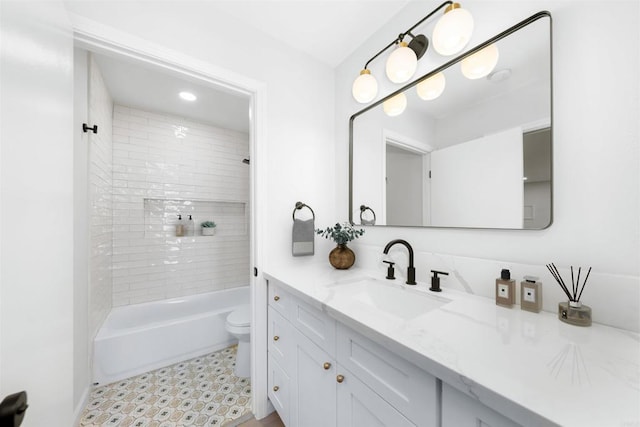 full bathroom featuring toilet, vanity, and tiled shower / bath combo