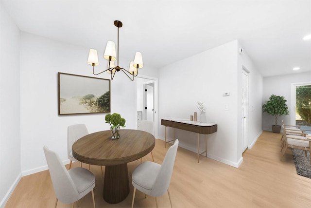 dining area featuring a notable chandelier and light wood-type flooring