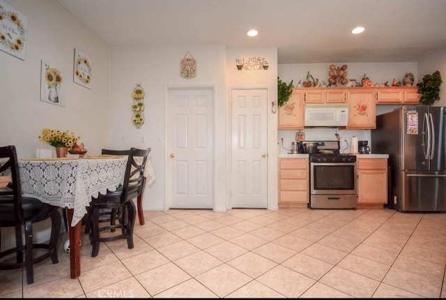 kitchen featuring light tile patterned flooring, stainless steel appliances, and light brown cabinetry