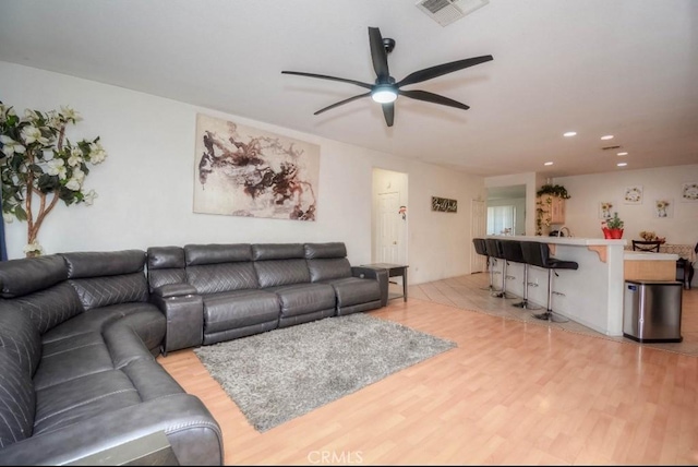 living room featuring ceiling fan and light wood-type flooring