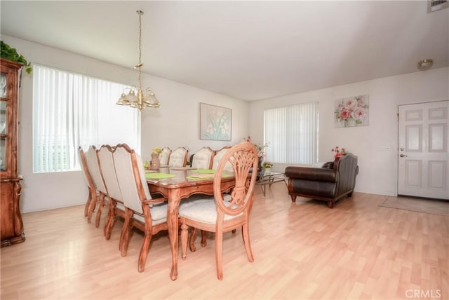 dining room featuring an inviting chandelier and light wood-type flooring