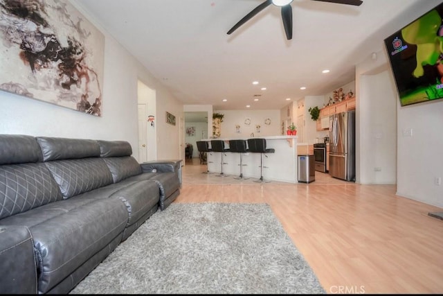 living room featuring ceiling fan and light hardwood / wood-style flooring