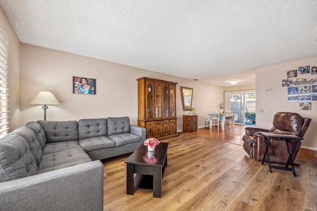 living room featuring light wood-type flooring and a textured ceiling