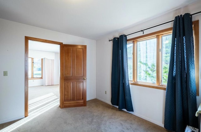 unfurnished room with light colored carpet and lofted ceiling