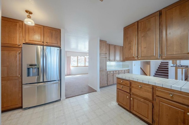 kitchen with tile counters and stainless steel refrigerator with ice dispenser