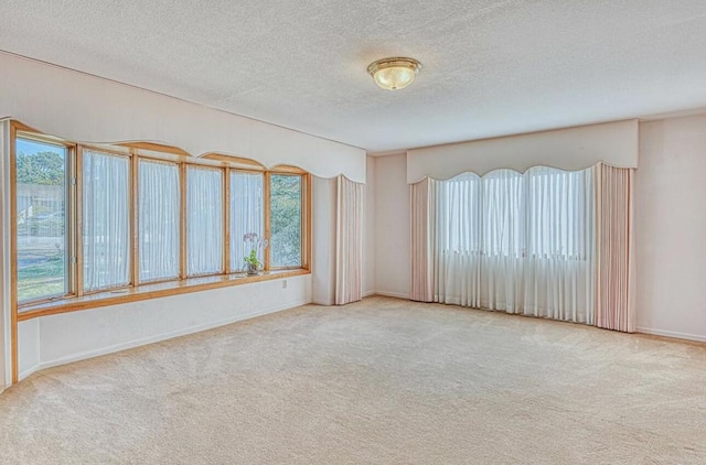 unfurnished room with a textured ceiling and carpet