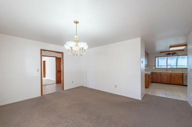 unfurnished dining area with sink, an inviting chandelier, and light colored carpet