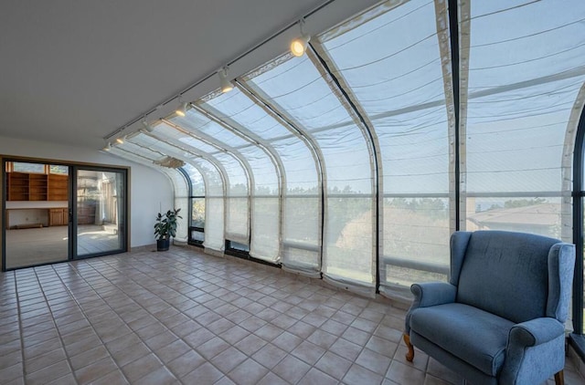 unfurnished sunroom with rail lighting