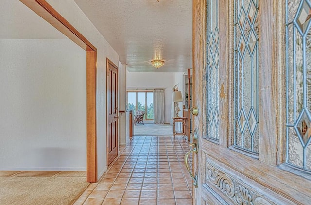 hallway featuring light tile patterned floors and a textured ceiling