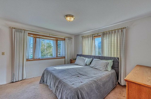 bedroom with light colored carpet and multiple windows