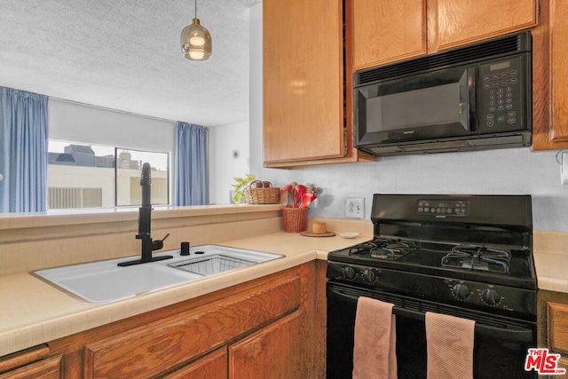 kitchen with sink, black appliances, a textured ceiling, and decorative light fixtures