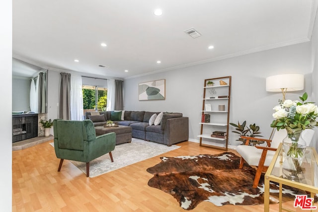 living room with light wood-type flooring and ornamental molding