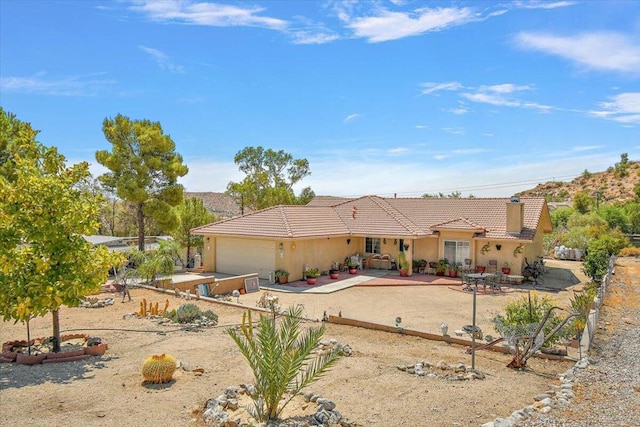 view of front of property with a garage and a patio area