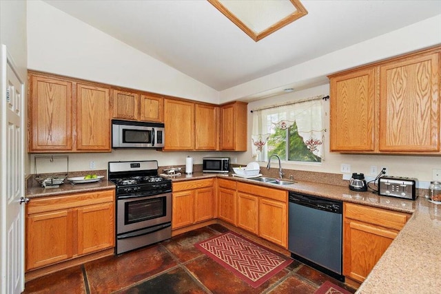 kitchen with sink, appliances with stainless steel finishes, and lofted ceiling