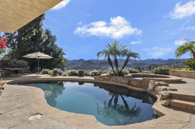 view of swimming pool with a mountain view, an in ground hot tub, and a patio area