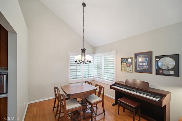 dining area featuring vaulted ceiling, an inviting chandelier, and wood-type flooring