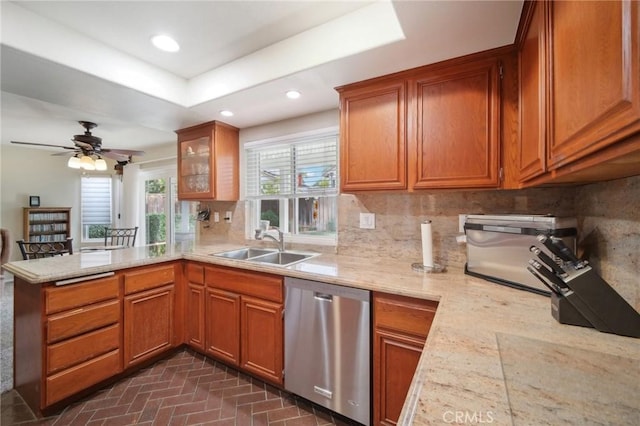 kitchen with decorative backsplash, sink, light stone counters, and dishwasher