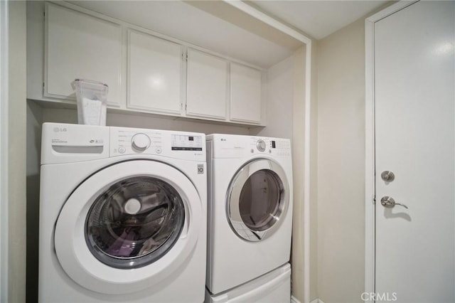 laundry room featuring cabinets and washing machine and dryer