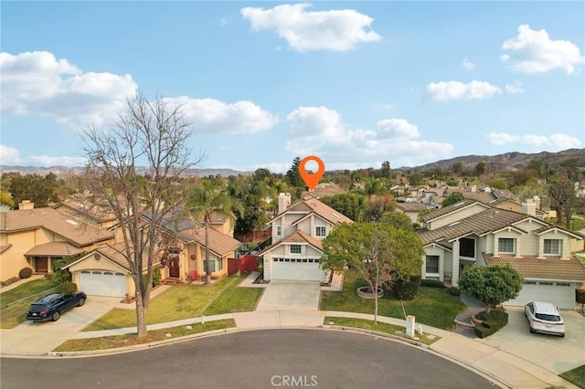 view of front of home featuring a mountain view, a front yard, and a garage