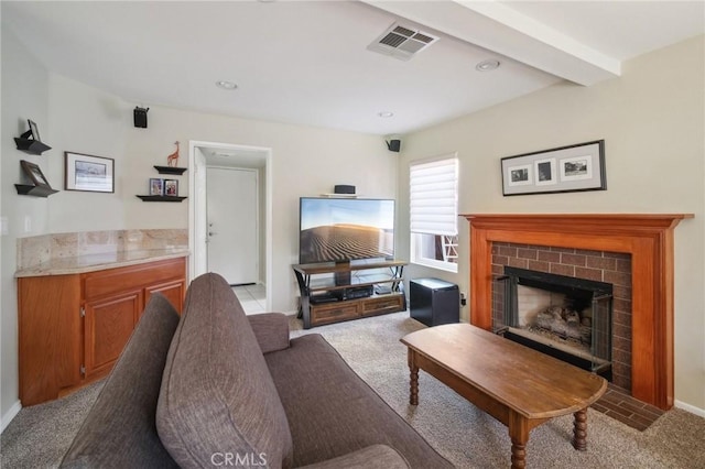 living room with a brick fireplace, light colored carpet, and beamed ceiling