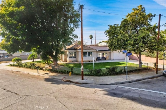 single story home featuring a garage and a front lawn