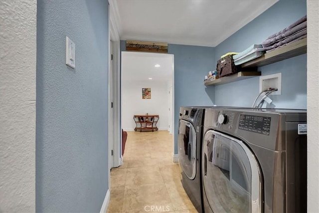 laundry area featuring washing machine and dryer, ornamental molding, and light tile patterned floors