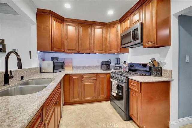 kitchen featuring stainless steel appliances, light stone countertops, and sink