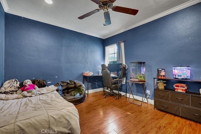 bedroom with crown molding, wood-type flooring, and ceiling fan