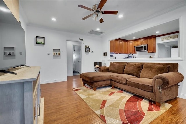 living room with ceiling fan and light wood-type flooring