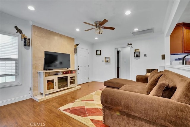 living room featuring ceiling fan and light hardwood / wood-style flooring