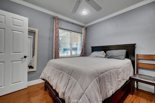 bedroom featuring hardwood / wood-style floors, crown molding, and ceiling fan