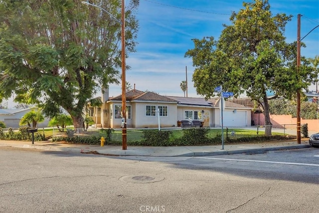 single story home with a garage and solar panels