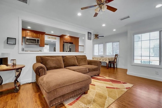 living room featuring ceiling fan and light hardwood / wood-style floors