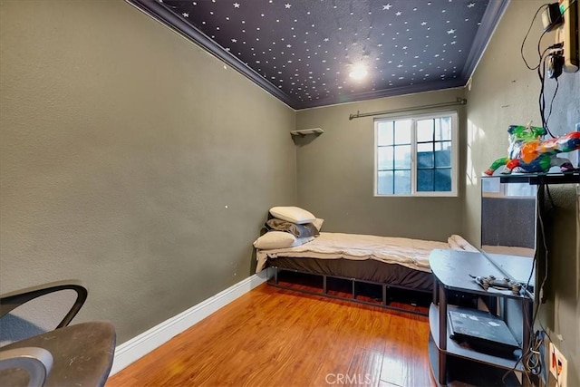 bedroom featuring ornamental molding and wood-type flooring