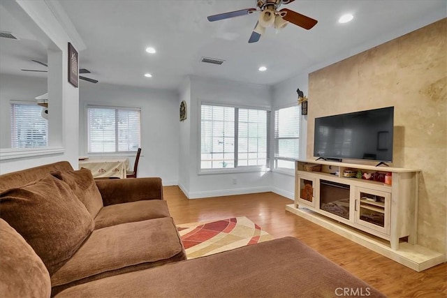 living room featuring plenty of natural light, light hardwood / wood-style floors, and ceiling fan