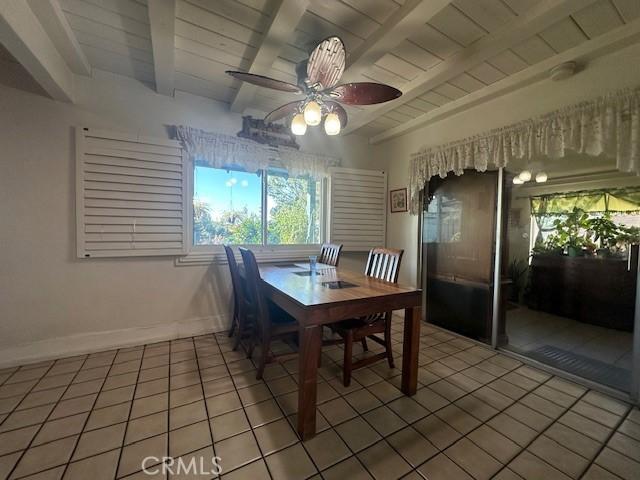 dining area featuring wood ceiling, beam ceiling, and tile patterned flooring