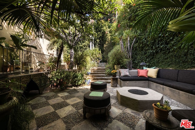 view of patio with an outdoor living space with a fire pit