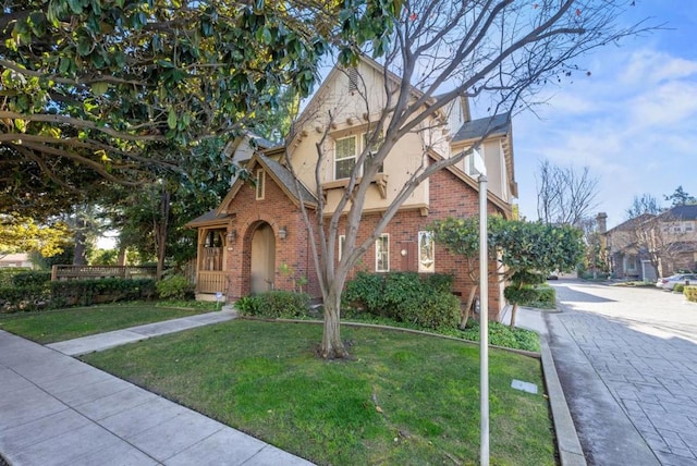 tudor-style house featuring a front lawn