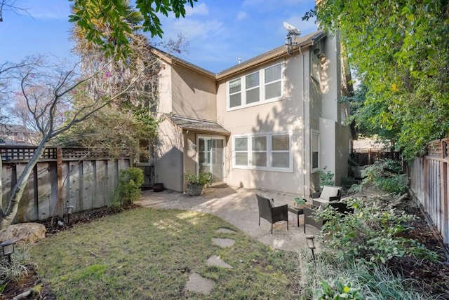 back of property featuring a patio area and a lawn