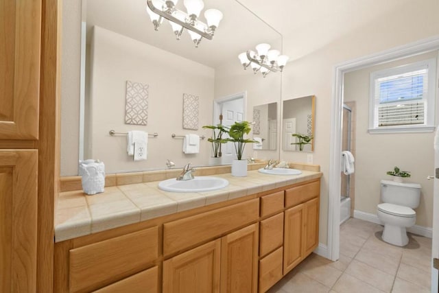 full bathroom featuring combined bath / shower with glass door, vanity, tile patterned floors, toilet, and a chandelier