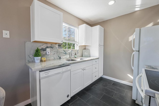 kitchen with backsplash, white appliances, white cabinetry, and light stone counters