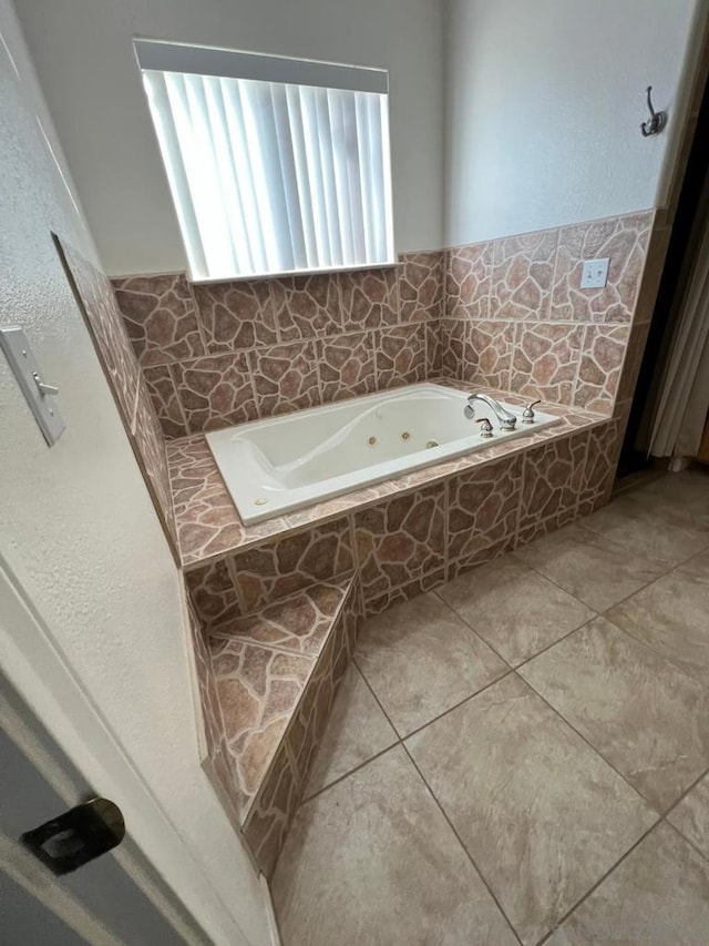 bathroom featuring a relaxing tiled tub and tile patterned floors